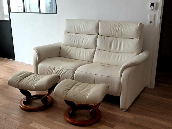 Canapé cuir blanc 2 places + 2 repose-pieds.